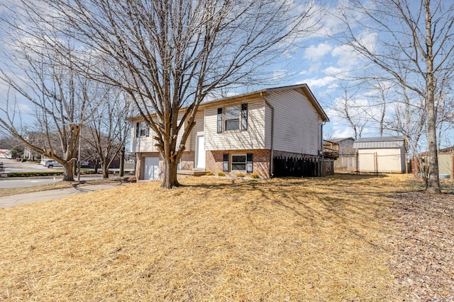 view of front of house with driveway, a garage, fence, and brick siding