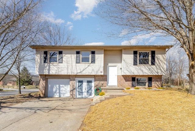 bi-level home featuring brick siding, driveway, and an attached garage