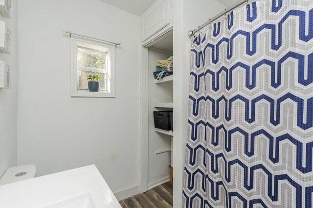 full bathroom featuring a shower with curtain, toilet, and wood finished floors