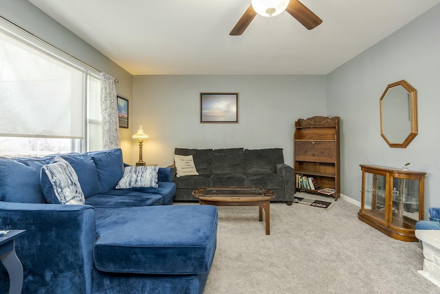 carpeted living room with a ceiling fan and baseboards