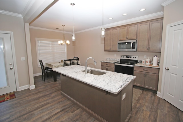 kitchen with light stone counters, a sink, appliances with stainless steel finishes, a center island with sink, and pendant lighting