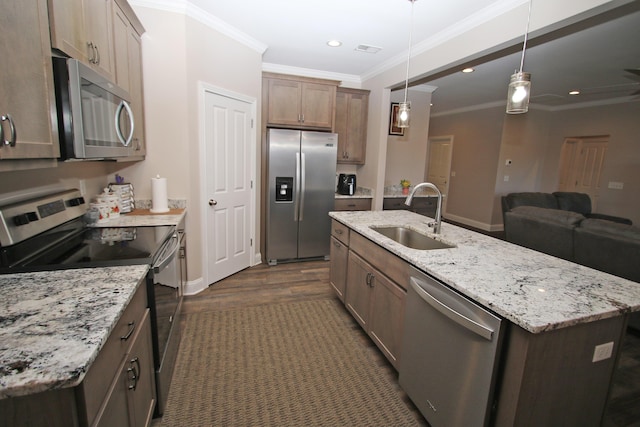 kitchen with a kitchen island with sink, recessed lighting, a sink, appliances with stainless steel finishes, and pendant lighting