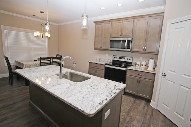 kitchen featuring pendant lighting, stainless steel microwave, electric range oven, a kitchen island with sink, and a sink