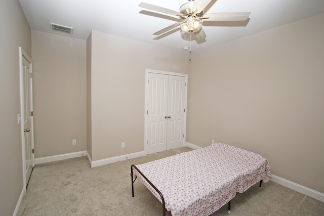 bedroom featuring a closet, visible vents, light carpet, ceiling fan, and baseboards