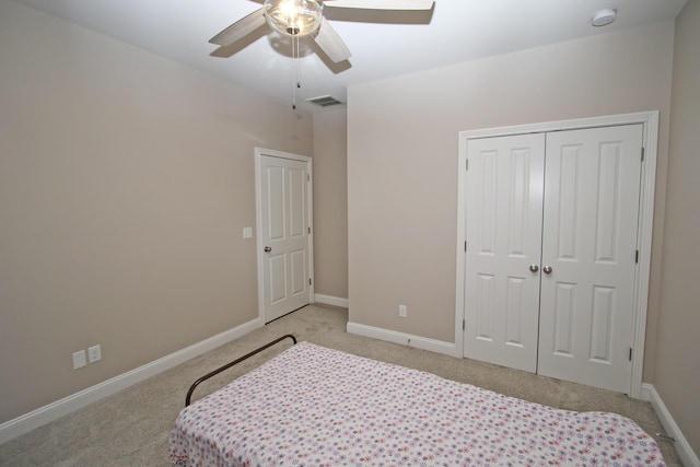 bedroom with baseboards, visible vents, a closet, and light colored carpet