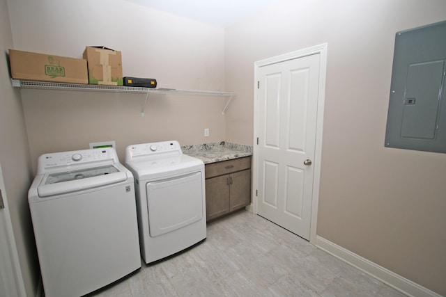 washroom with washing machine and dryer, light wood-style floors, baseboards, cabinet space, and electric panel