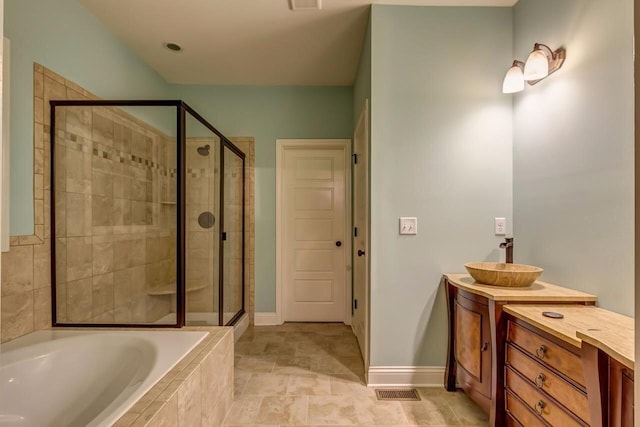 bathroom with visible vents, vanity, baseboards, a shower stall, and a bath