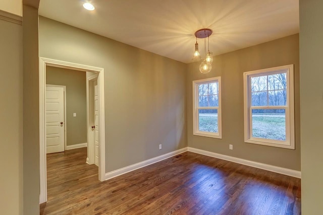 spare room with dark wood-style flooring and baseboards