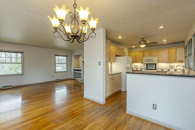 kitchen featuring visible vents, white appliances, light wood-style floors, and dark countertops