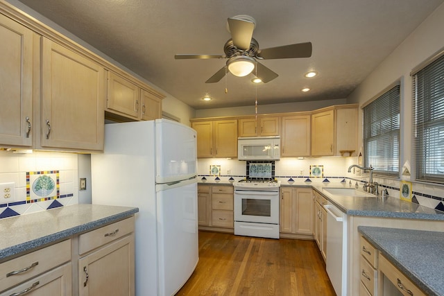 kitchen with a sink, white appliances, dark wood-style floors, and light brown cabinets