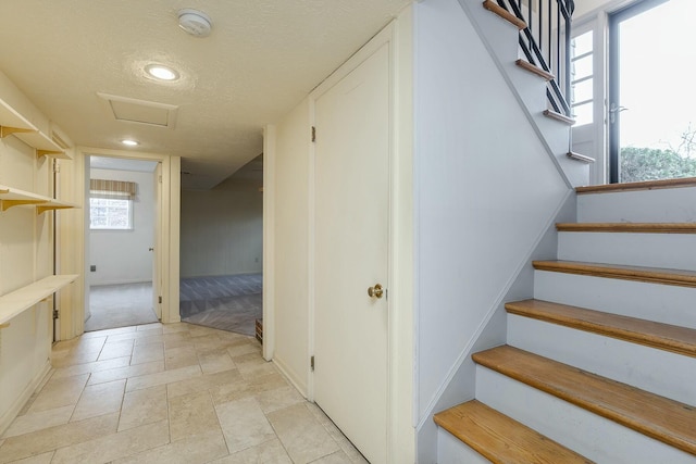 stairway featuring recessed lighting, a textured ceiling, and attic access