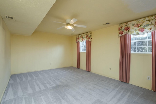 unfurnished room featuring visible vents, ceiling fan, and carpet flooring