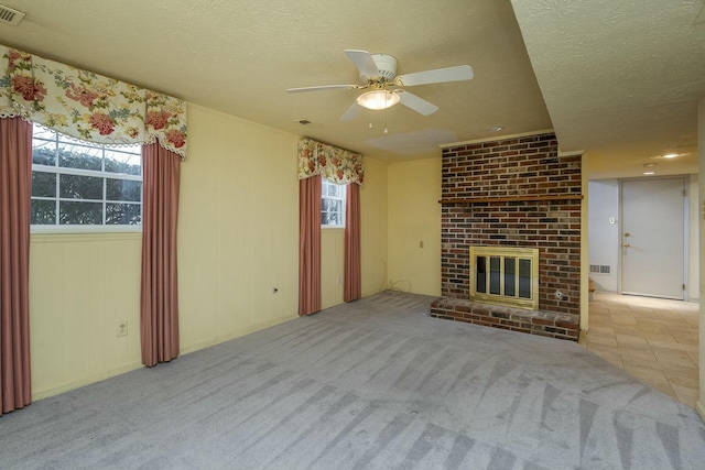 unfurnished living room with visible vents, a textured ceiling, ceiling fan, and carpet floors