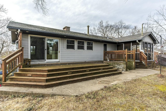 rear view of house with a chimney and a wooden deck