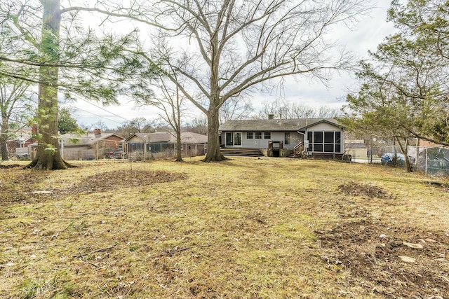 view of yard with fence and a sunroom