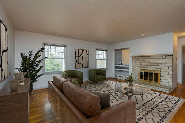 living area featuring a wealth of natural light, a textured ceiling, and wood finished floors