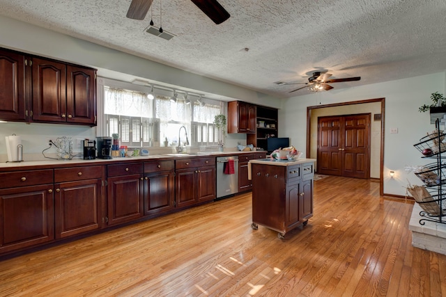 kitchen with a ceiling fan, light countertops, light wood finished floors, and stainless steel dishwasher