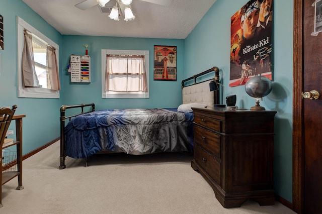 carpeted bedroom with ceiling fan and baseboards