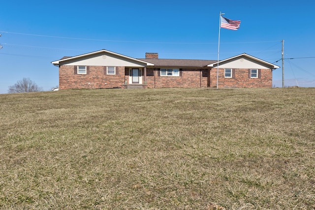 ranch-style house with a chimney, a front lawn, and brick siding