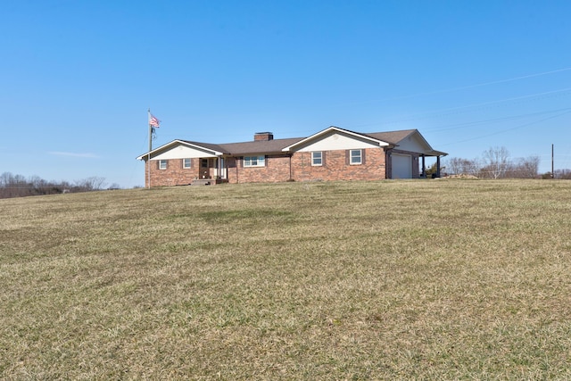 single story home with an attached garage, a chimney, and a front yard