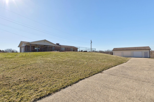 view of yard with a garage and an outbuilding