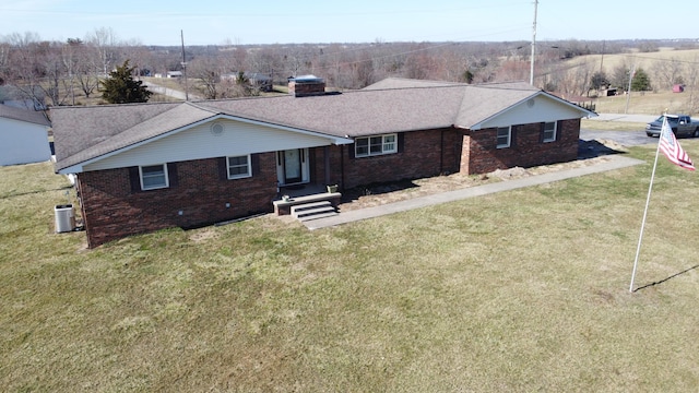 exterior space with brick siding, roof with shingles, a front lawn, and central air condition unit