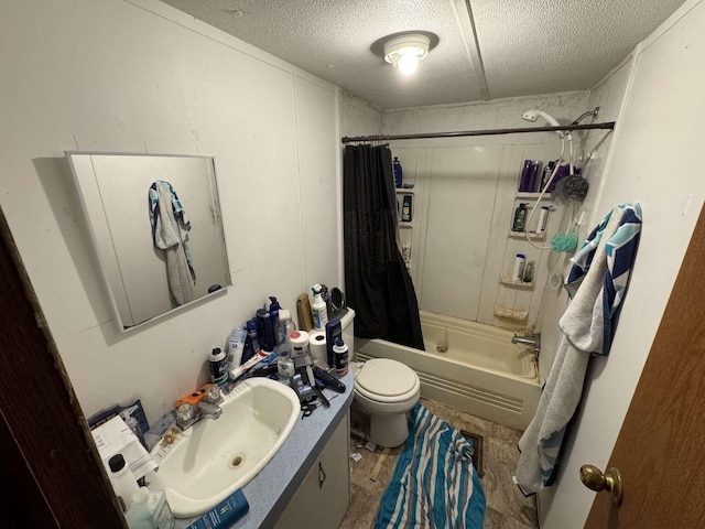 bathroom featuring toilet, shower / bath combo with shower curtain, a textured ceiling, and vanity