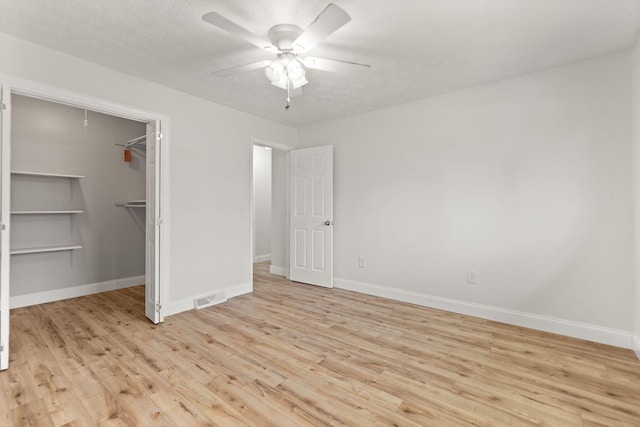 unfurnished bedroom with a textured ceiling, light wood finished floors, visible vents, and baseboards