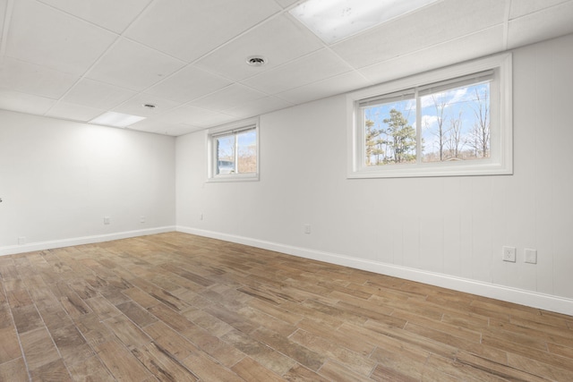 unfurnished room featuring a paneled ceiling, baseboards, and wood finished floors