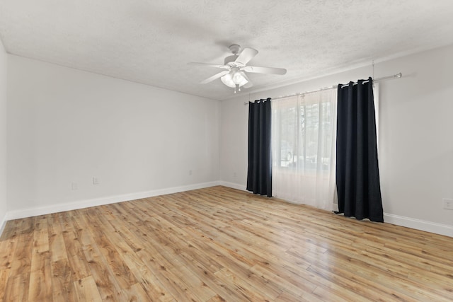 unfurnished room featuring light wood-style floors, ceiling fan, a textured ceiling, and baseboards