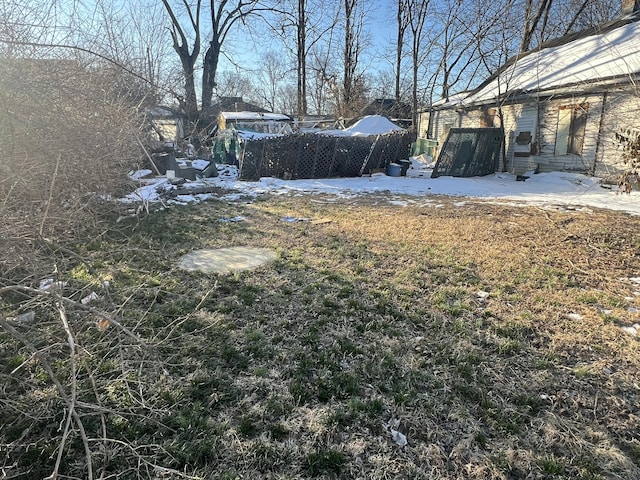 yard covered in snow featuring entry steps and fence