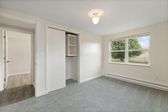 unfurnished bedroom featuring a closet, baseboards, baseboard heating, and carpet flooring