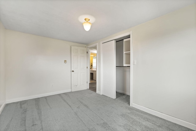 unfurnished bedroom featuring carpet, a closet, and baseboards