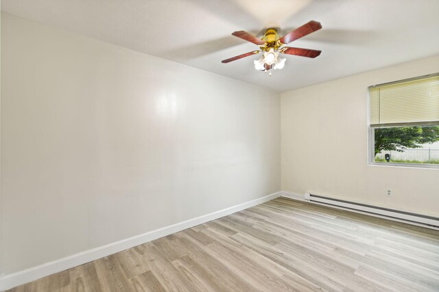 unfurnished room with a baseboard heating unit, a ceiling fan, light wood-style flooring, and baseboards