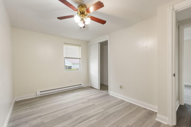 unfurnished bedroom with ceiling fan, a baseboard radiator, baseboards, a closet, and light wood finished floors