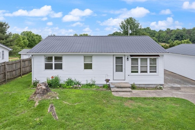 view of front of house featuring fence, metal roof, and a front yard