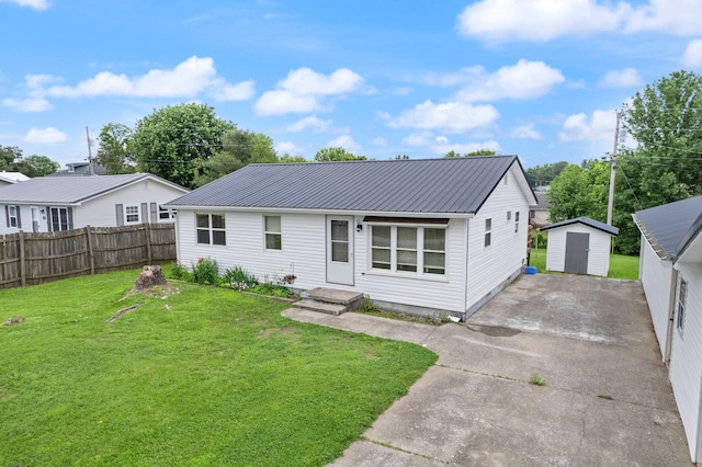 single story home with an outbuilding, metal roof, a storage shed, and a front yard