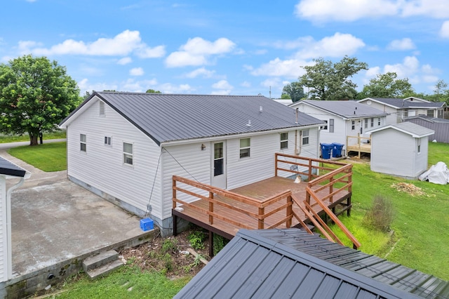 rear view of house featuring a residential view, metal roof, a lawn, and a wooden deck