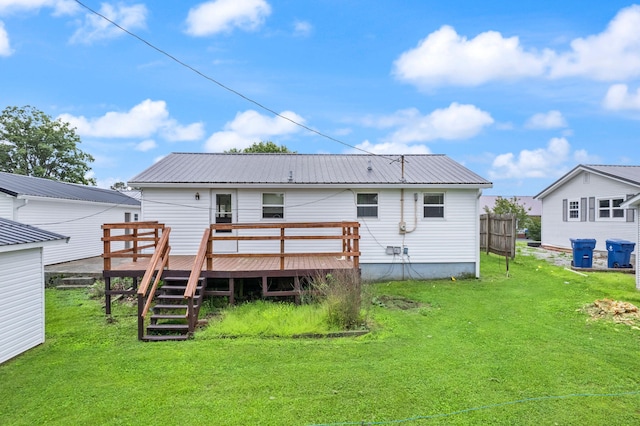 rear view of house with metal roof, a yard, stairway, and a wooden deck