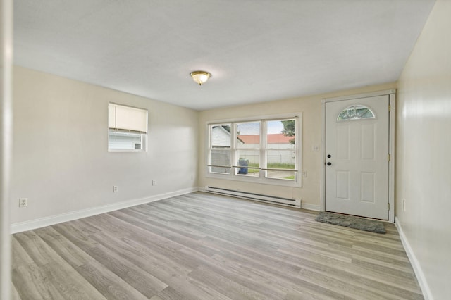 foyer featuring light wood-style floors, a baseboard radiator, and baseboards