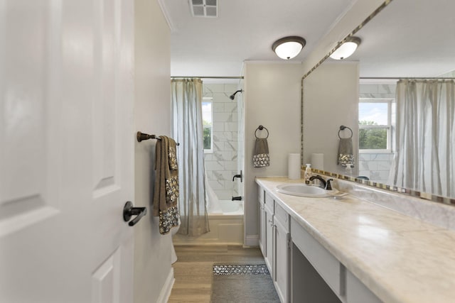 bathroom with visible vents, wood finished floors, shower / bath combination with curtain, and vanity