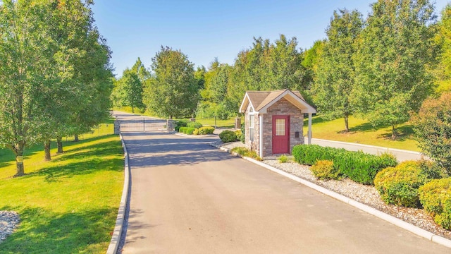 view of road with a gate and curbs