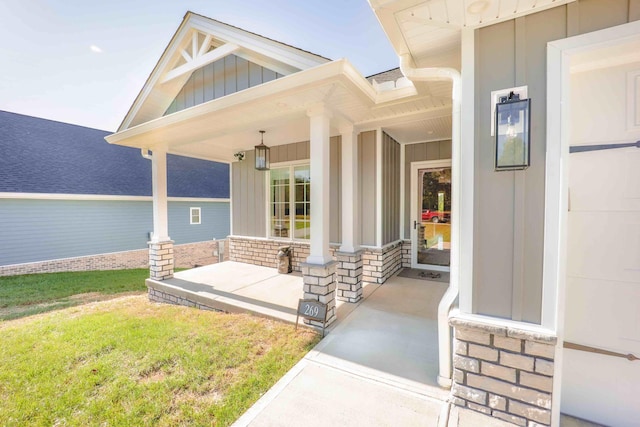 doorway to property featuring covered porch, stone siding, and board and batten siding