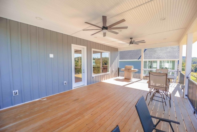 wooden deck with outdoor dining area, a grill, and a ceiling fan