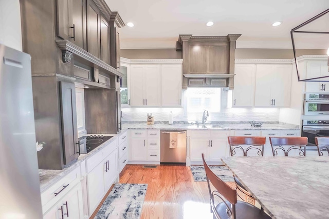 kitchen with glass insert cabinets, appliances with stainless steel finishes, white cabinetry, and a sink