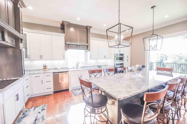 kitchen featuring stainless steel appliances, a breakfast bar, a kitchen island, and white cabinetry