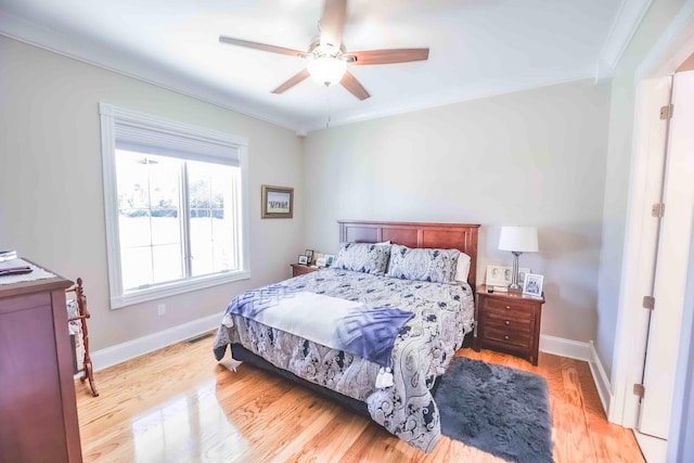 bedroom featuring light wood-style floors, ceiling fan, baseboards, and ornamental molding