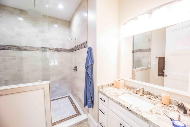 bathroom featuring walk in shower and vanity