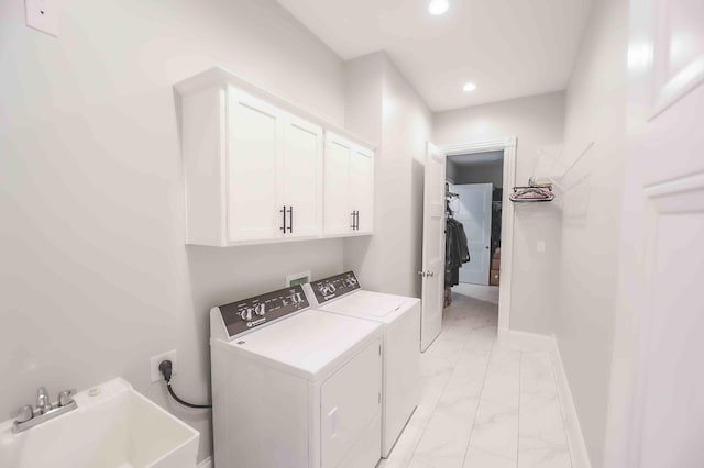 washroom featuring marble finish floor, cabinet space, a sink, washer and dryer, and baseboards