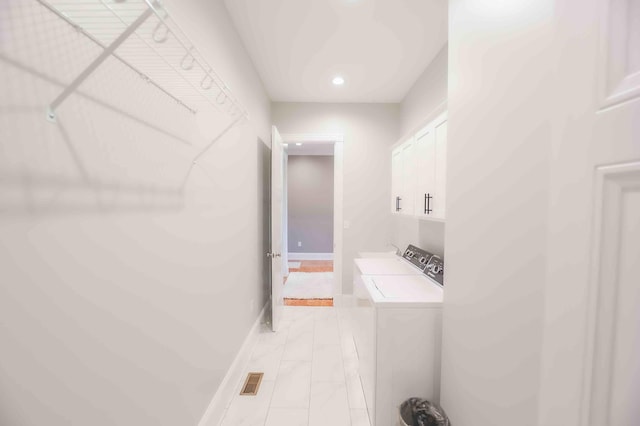 washroom featuring marble finish floor, cabinet space, and washing machine and clothes dryer